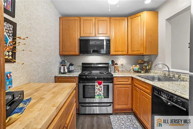 a kitchen with stainless steel appliances granite countertop a stove a sink and a microwave