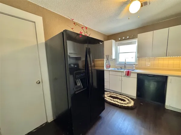 a kitchen with a refrigerator and a stove top oven