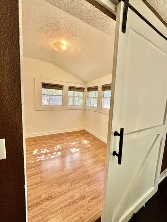 a view of a room with wooden floor and white walls