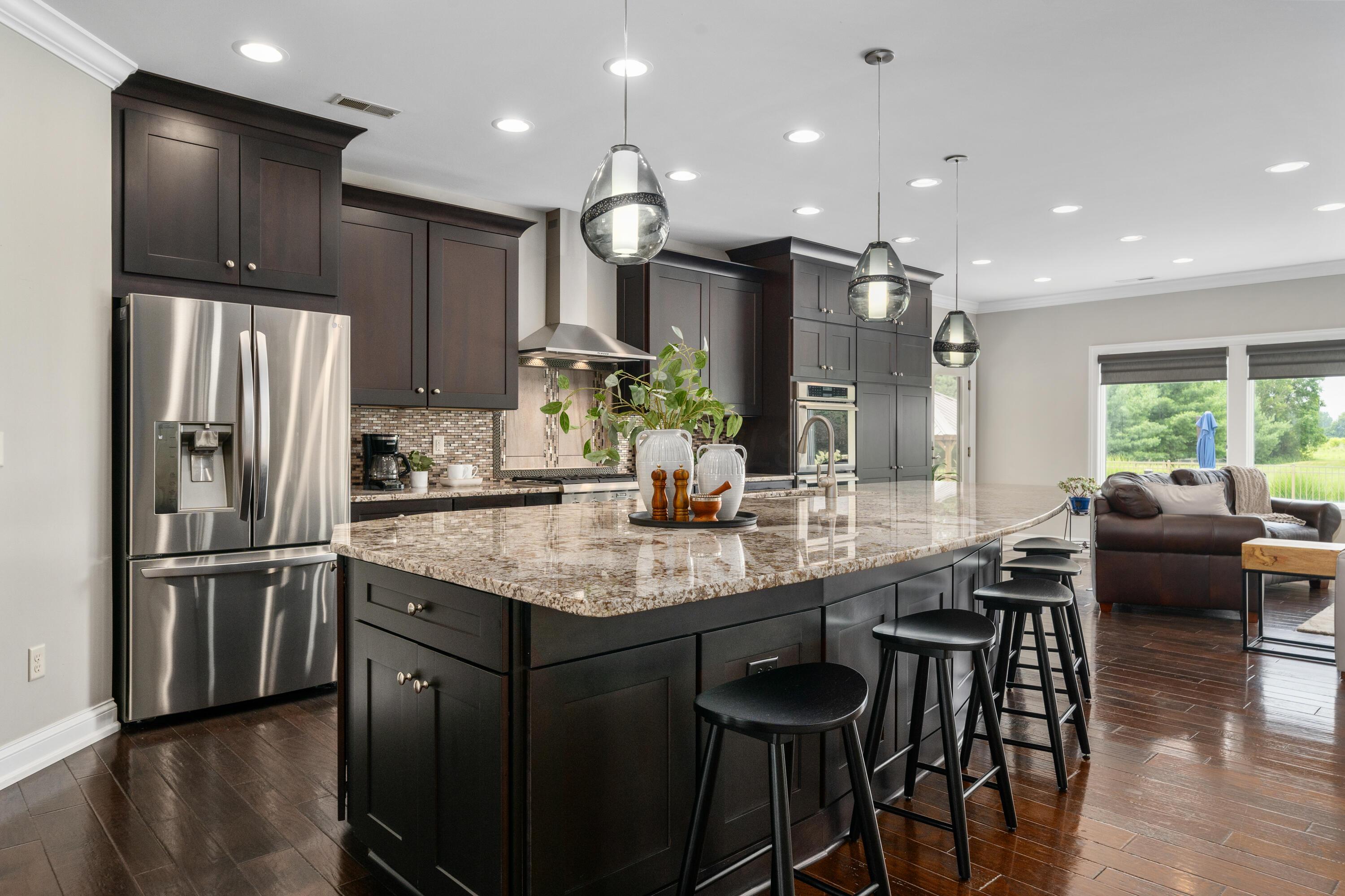 4640 Maynard Road Delaware, OH 43015 - Photo 10 of 91 Open-concept kitchen featuring, stainless steel appliances, a large center island with a stone-finish countertop, and pendant lighting