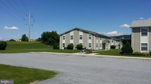 a view of a house with a big yard and large tree