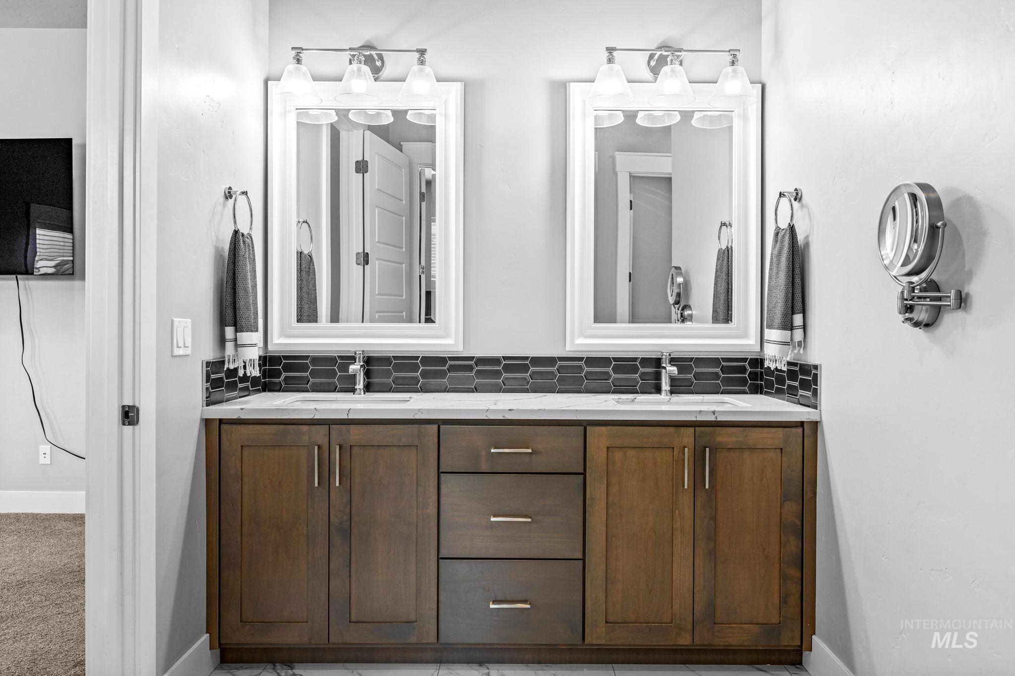 2934 East Murchison Street Meridian, ID 83642 - Photo 24 of 44 Double vanity with wood-finish cabinetry, integrated sinks, and white countertops