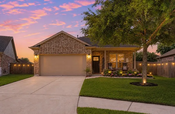 a front view of a house with a yard and green space