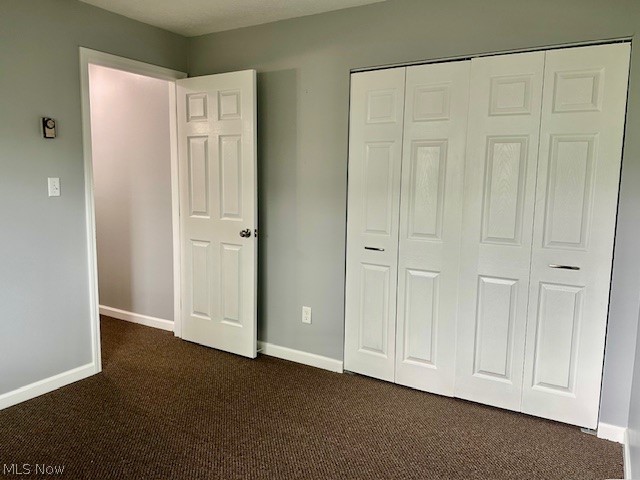 4376 Darrow Road, Unit 2 Stow, OH 44224 - Photo 20 of 26 Unfurnished bedroom featuring dark carpet, a closet, and baseboards