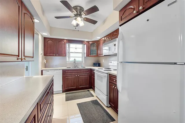 a kitchen with stainless steel appliances granite countertop a refrigerator a stove a sink and a microwave