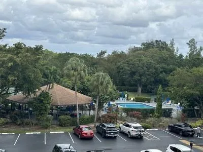 an outdoor space with lots of cars parked on the roadside