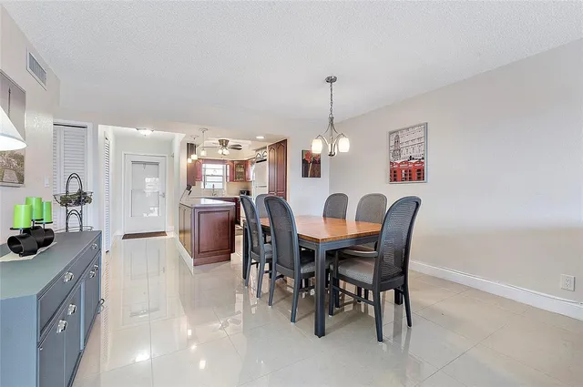 a view of a dining room and livingroom with furniture a chandelier and wooden floor