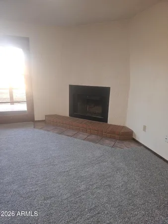 an empty room with a window and a ceiling fan