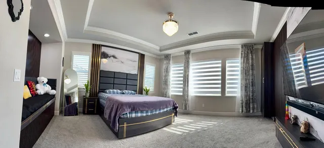 a bedroom with a bed a flat tv and a mirror