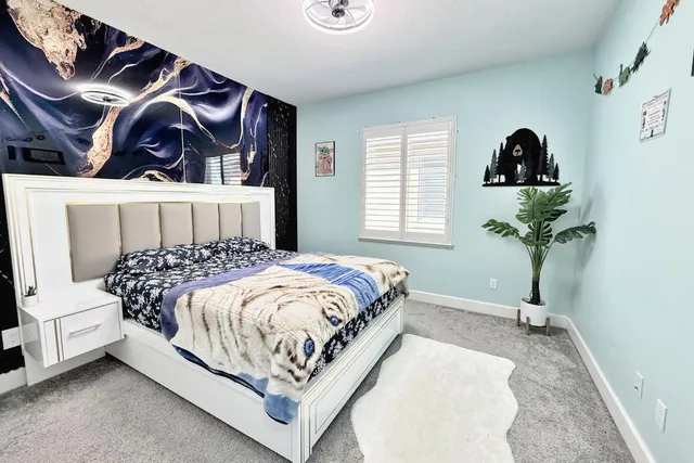 a bedroom with a large bed and a wooden floor