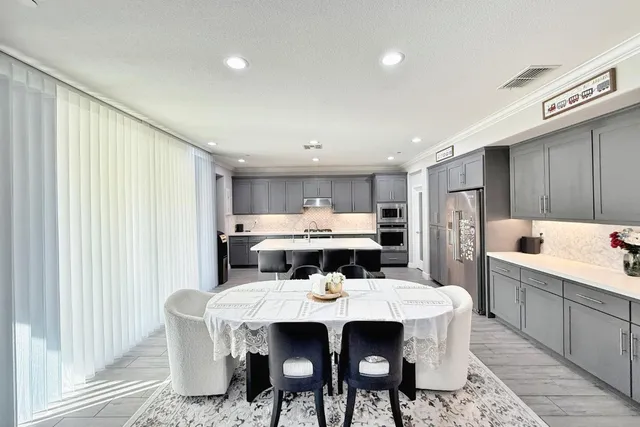 a kitchen with stainless steel appliances granite countertop a stove top oven a sink dishwasher and a refrigerator with wooden floor