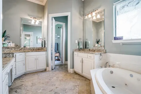 a bathroom with a tub sink and mirror