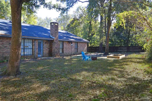 a view of a house with backyard and sitting area