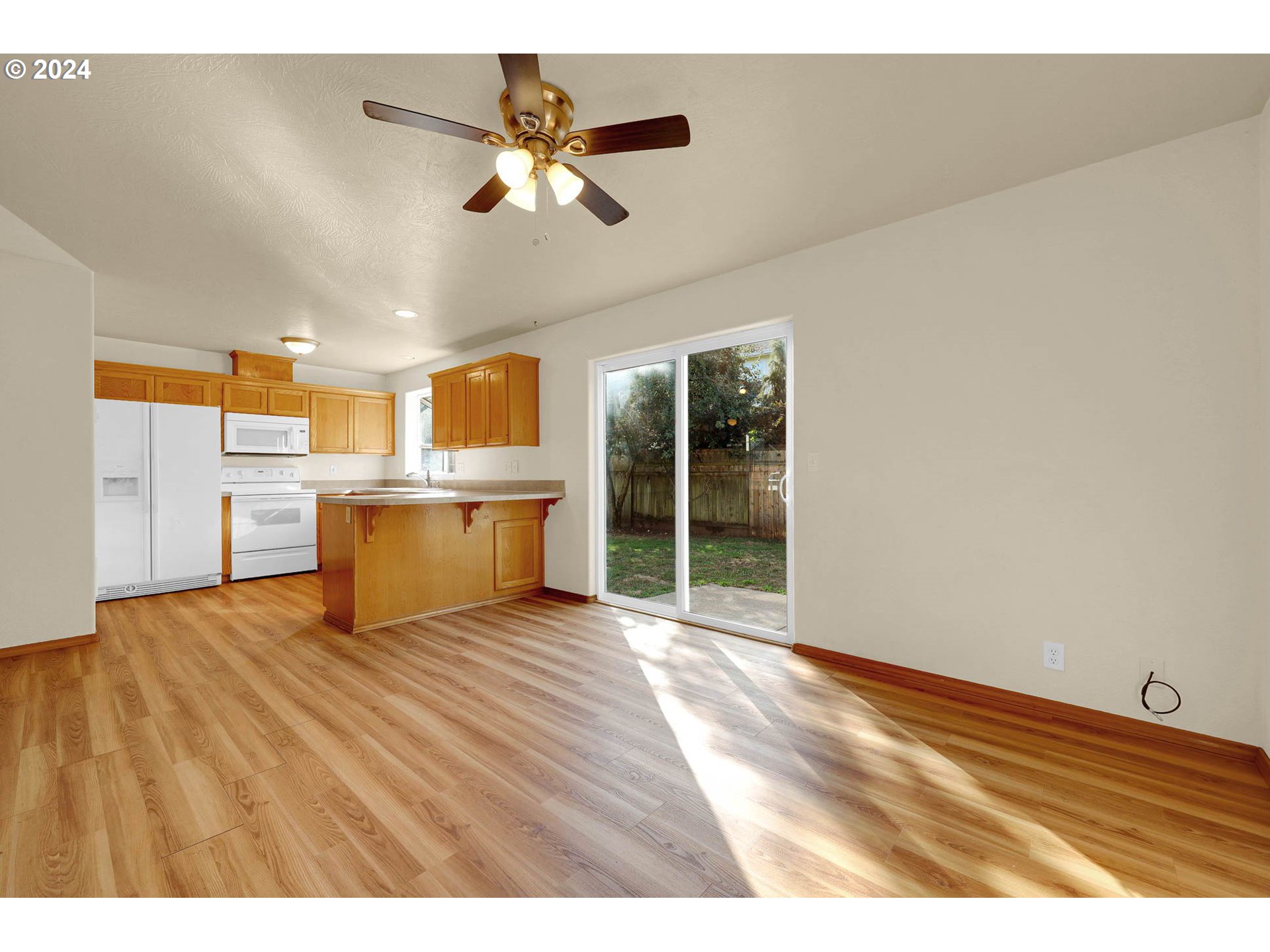 537 Nicholas Drive Springfield, OR 97477 - Photo 12 of 37 a view of a kitchen with a stove cabinets a ceiling fan and wooden floor