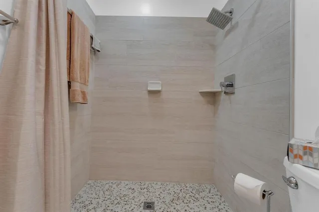 a bathroom with a granite countertop sink a toilet and shower