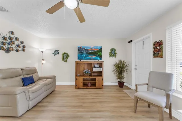 a view of a hallway with furniture and wooden floor