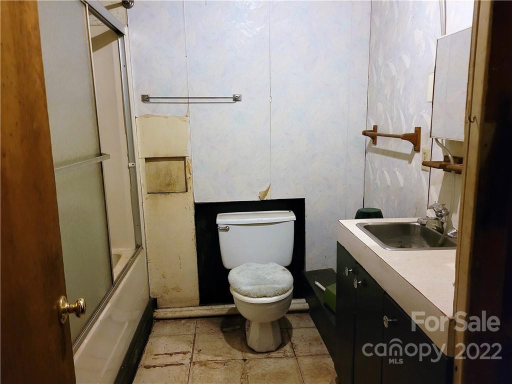 941 Engineer Road Bostic, NC 28018 - Photo 24 of 29 a bathroom with a granite countertop toilet sink and a mirror