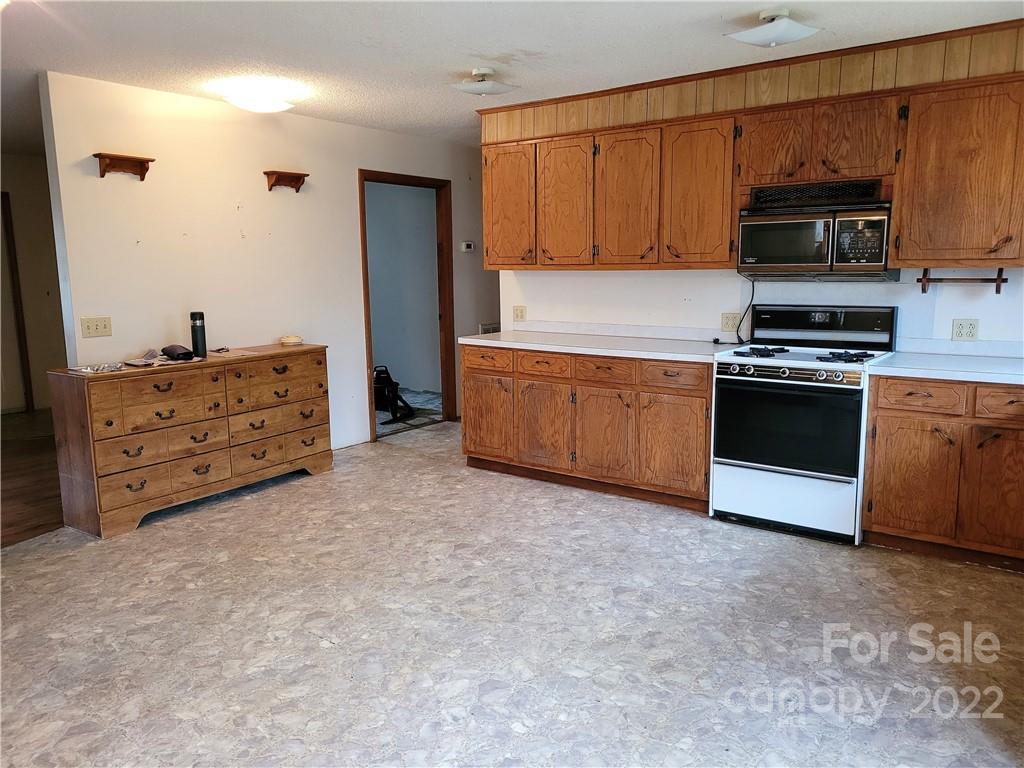 941 Engineer Road Bostic, NC 28018 - Photo 8 of 29 a kitchen with stainless steel appliances granite countertop a stove a sink and a refrigerator