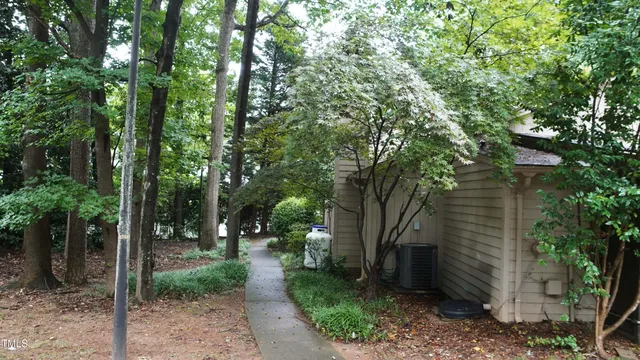 a view of small white house with large windows and a small yard