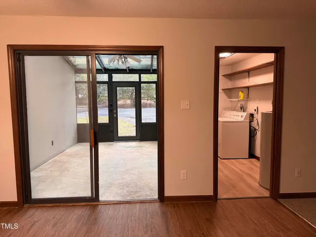 a view of a hallway with wooden floor and dining room