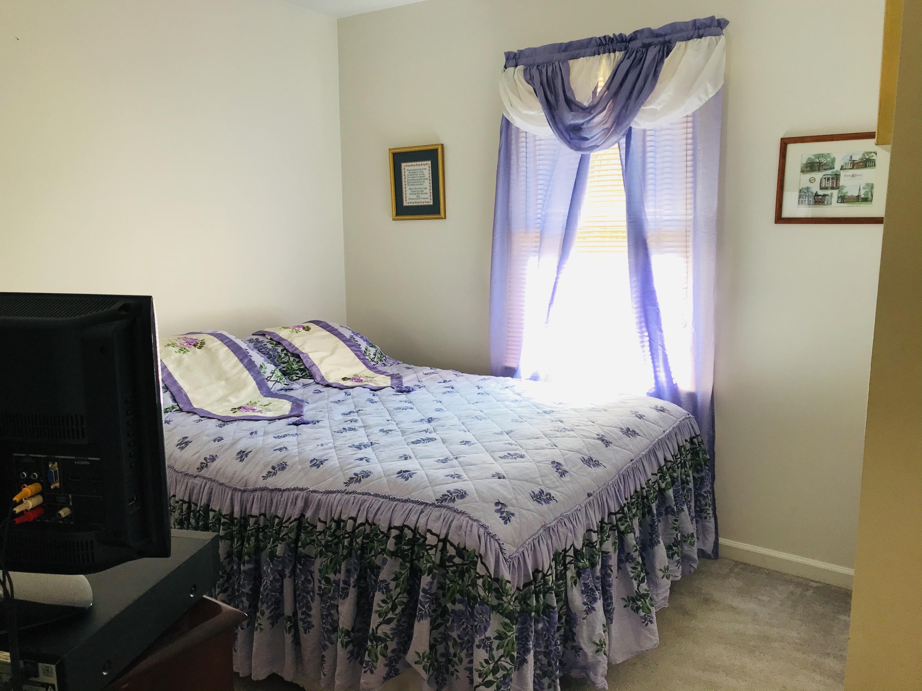 214 Highland Lake Road Union Hall, VA 24176 - Photo 12 of 33 a bed sitting in a bedroom next to a window with a flat tv screen and a dresser