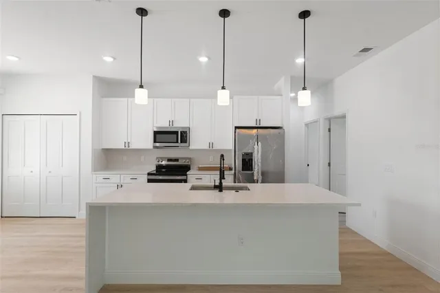 a kitchen with stainless steel appliances a refrigerator sink and stove