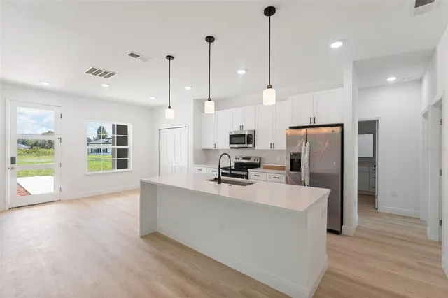 a kitchen with stainless steel appliances granite countertop a sink and a refrigerator