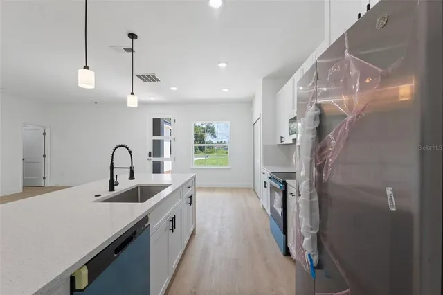 a kitchen with a sink stove and microwave