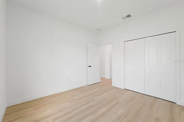 an empty room with wooden floor and window