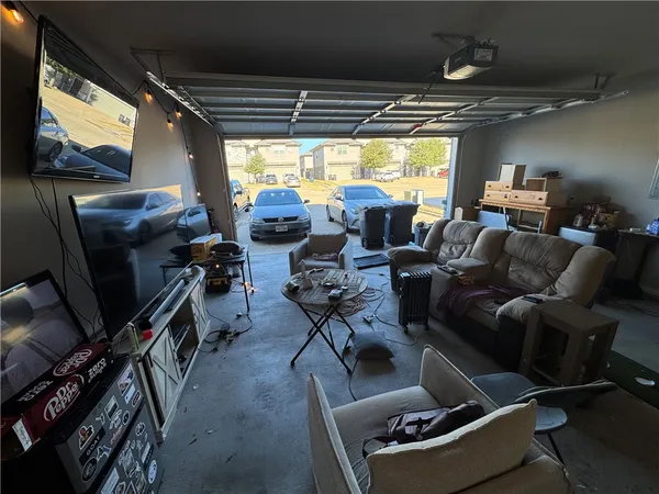 a living room with furniture a flat screen tv and a window