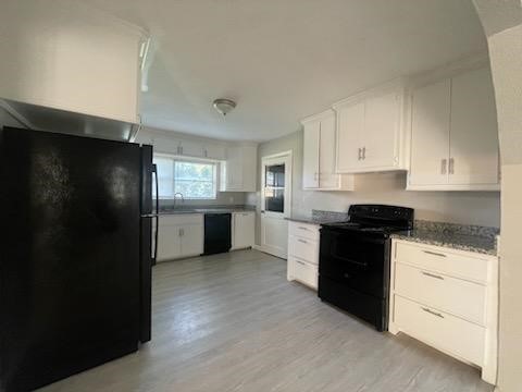 1114 East Pecan Street Angleton, TX 77515 - Photo 2 of 20 a kitchen with granite countertop white cabinets and refrigerator