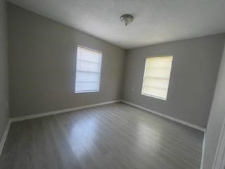 1114 East Pecan Street Angleton, TX 77515 - Photo 7 of 20 an empty room with wooden floor and windows