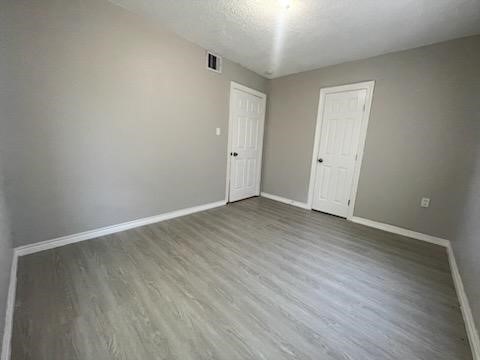 1114 East Pecan Street Angleton, TX 77515 - Photo 8 of 20 a view of an empty room with wooden floor