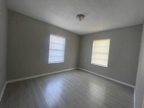 1114 East Pecan Street Angleton, TX 77515 - Photo 9 of 20 an empty room with wooden floor and windows