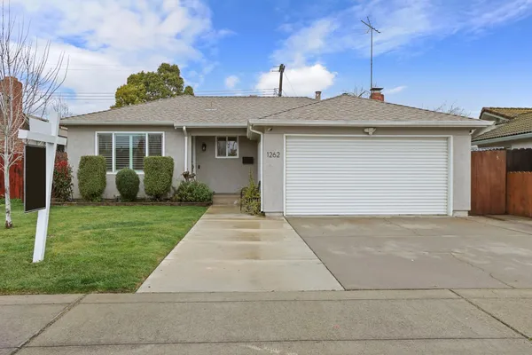 a front view of a house with a yard and trees