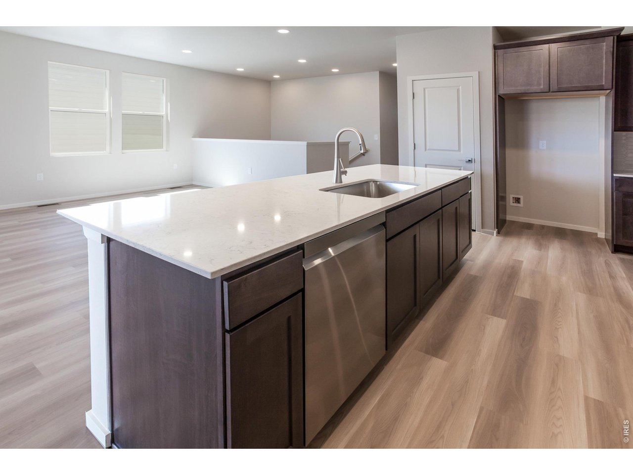 792 Chatter Road Windsor, CO 80550 - Photo 18 of 49 a kitchen with a sink a refrigerator and wooden cabinets