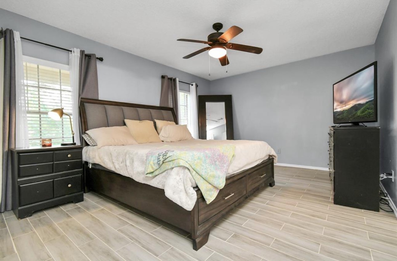 10234 Tablerock Drive Houston, TX 77064 - Photo 14 of 20 a bedroom with a bed and a chandelier