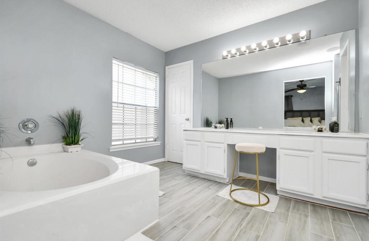 10234 Tablerock Drive Houston, TX 77064 - Photo 15 of 20 a bathroom with a tub a sink and a mirror