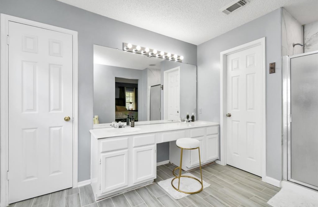 10234 Tablerock Drive Houston, TX 77064 - Photo 16 of 20 a bathroom with a double vanity sink and a mirror