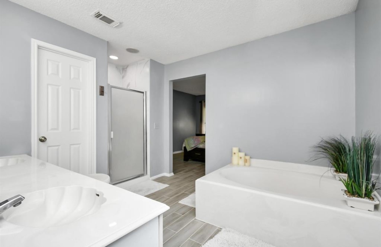 10234 Tablerock Drive Houston, TX 77064 - Photo 17 of 20 a en suite spacious bathroom with a tub shower and a mirror