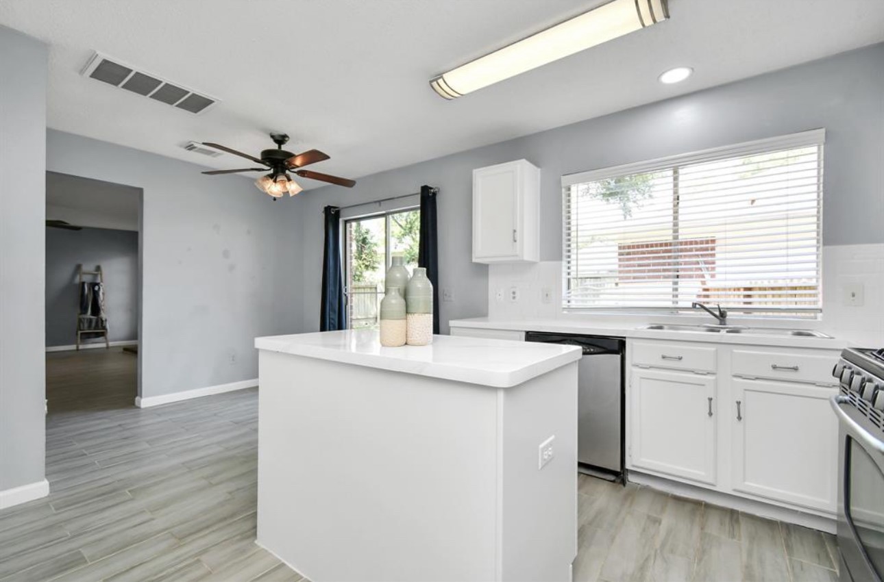 10234 Tablerock Drive Houston, TX 77064 - Photo 9 of 20 a kitchen with stainless steel appliances granite countertop a sink and dishwasher with wooden floor