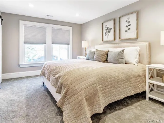 a bed sitting in a bedroom next to a window