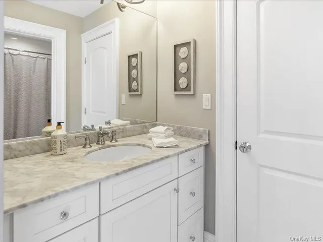 a bathroom with a granite countertop sink and a mirror