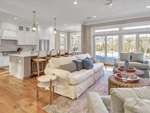 a living room with furniture kitchen and a large window