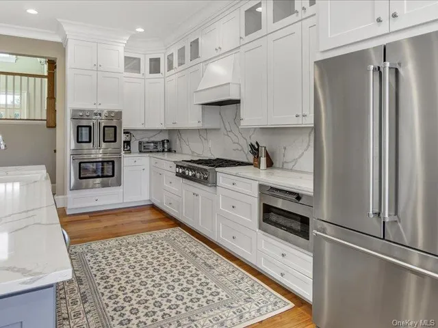 a kitchen with stainless steel appliances granite countertop a refrigerator sink and stove