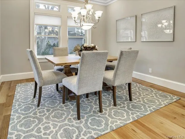 a view of a dining room with furniture a chandelier and wooden floor