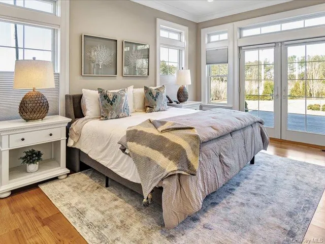 a bedroom with a bed and large windows