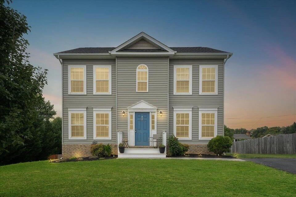 a front view of a house with a yard and trees
