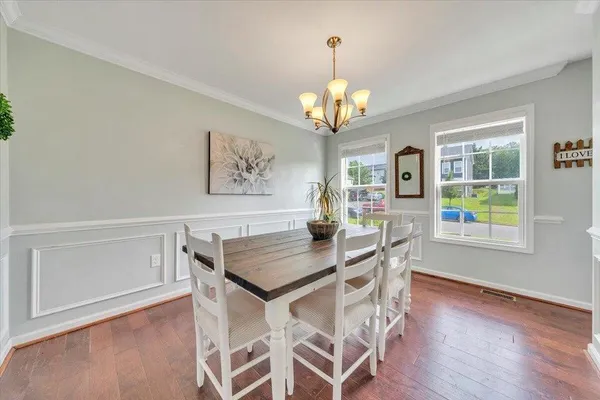 a view of a dining room with furniture a chandelier and wooden floor