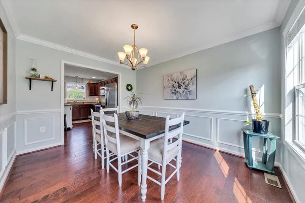 a view of a dining room with furniture wooden floor and chandelier